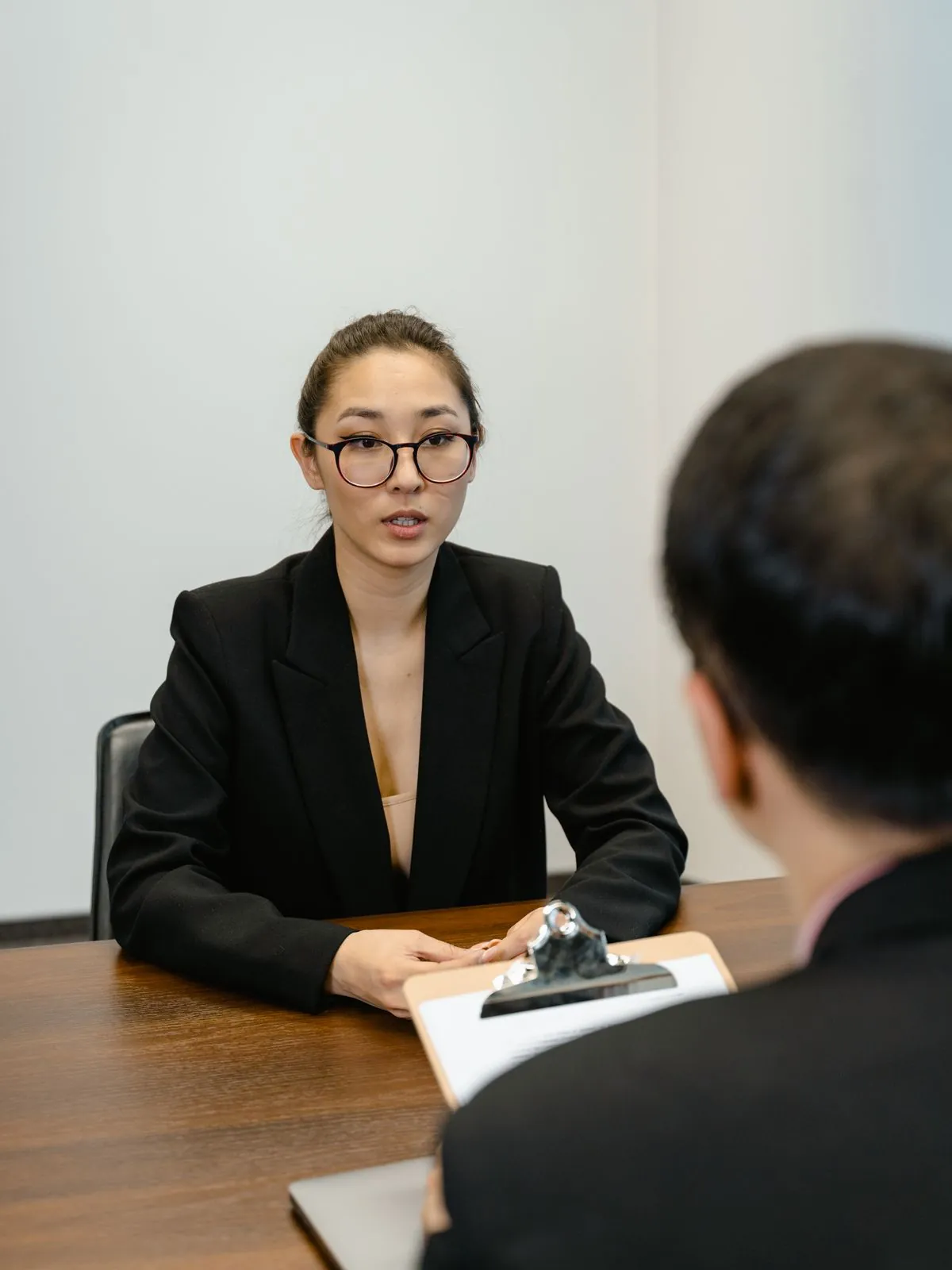 A candidate at a kitchen table with a phone and a notebook, the job search in progress